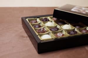 Nahaufnahme einer befüllten Pralinenschachtel. Prüfung, Packung, Packungsbestückung, Leistungen, Prüfung, Takt,